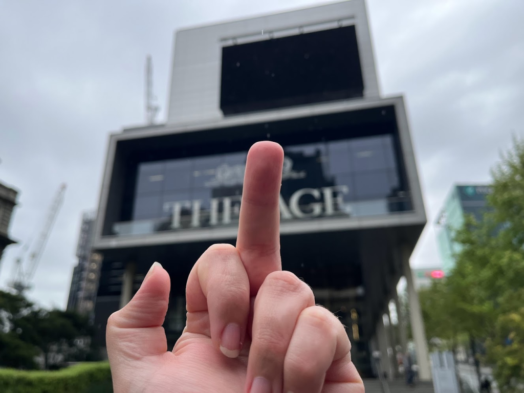 A rude finger pointed at The Age newspaper/online news resource branding on a building somewhere in Melbourne.